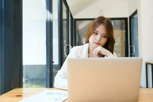 Businesswoman is working at office and using laptop. photo