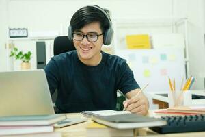 joven estudia frente a la computadora portátil en casa foto