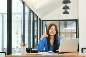 A female college student uses a computer to access the Internet for online learning. photo