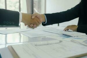 Close up businessman shaking hands with the client after finish the meeting. photo