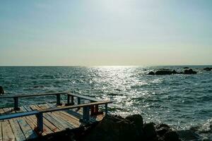 empty balcony and wooden bench with coast and sea background at Chedi Klang Nam in Chanthaburi, Thailand photo