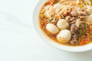 noodles with pork and meatballs in spicy soup photo