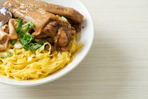 Egg noodles served dry with braised duck photo