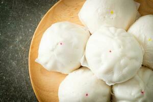 stuffed steamed bun on wood plate photo