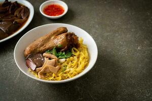 Egg noodles served dry with braised duck photo