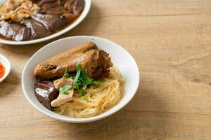 dried noodles with braised duck in white bowl photo