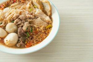 noodles with pork and meatballs in spicy soup photo