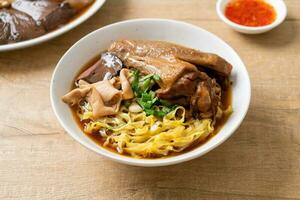 egg noodles with stewed and braised duck in brown soup photo