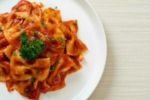 farfalle pasta in tomato sauce with parsley photo
