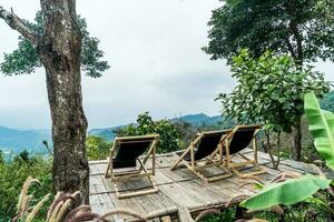 chair on balcony with mountain hill and foggy background photo