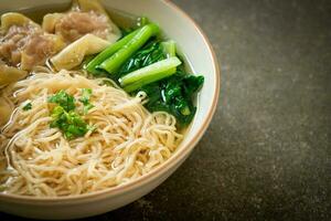 egg noodles with pork wonton soup or pork dumplings soup and vegetable photo