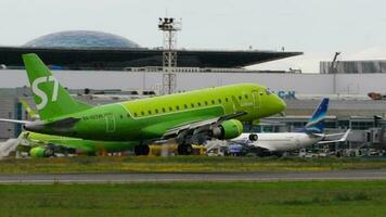 NOVOSIBIRSK, RUSSIAN FEDERATION JULY 15, 2022 - Passenger airplane of S7 Airlines landing, touching and braking, side view. Tourism and travel concept video