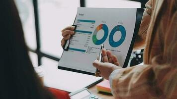 Financial analysts analyze business financial reports on a digital tablet planning investment project during a discussion at a meeting of corporate showing the results of their successful teamwork. video