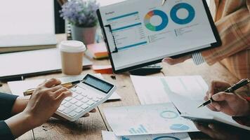 Financial analysts analyze business financial reports on a digital tablet planning investment project during a discussion at a meeting of corporate showing the results of their successful teamwork. video