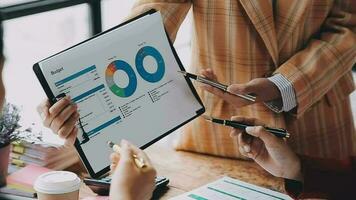 Financial analysts analyze business financial reports on a digital tablet planning investment project during a discussion at a meeting of corporate showing the results of their successful teamwork. video