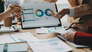 Financial analysts analyze business financial reports on a digital tablet planning investment project during a discussion at a meeting of corporate showing the results of their successful teamwork. video