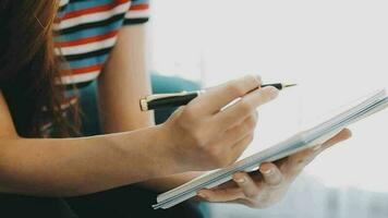 contento asiatico adolescente ragazza Tenere tampone computer aggeggio utilizzando digitale tavoletta tecnologia seduta su il divano a casa. sorridente giovane donna utilizzando app, shopping in linea, lettura notizia, navigazione Internet su divano video