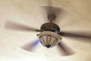 White fan rotates under roof in Playa del Carmen Mexico. photo