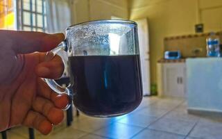 Taza de cristal de café negro de México sobre fondo de madera. foto