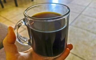 Glass cup of black coffee from Mexico on wooden background. photo