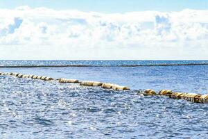 Blue water waves ocean with buoy buoys ropes nets Mexico. photo