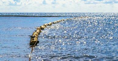 Blue water waves ocean with buoy buoys ropes nets Mexico. photo