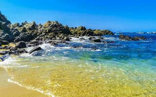 Beach sand blue turquoise water waves rocks panorama Puerto Escondido. photo