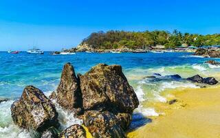 Beach sand blue turquoise water waves rocks panorama Puerto Escondido. photo