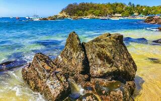 Beach sand blue turquoise water waves rocks panorama Puerto Escondido. photo