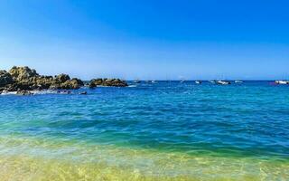 Beach sand blue turquoise water waves rocks panorama Puerto Escondido. photo