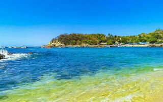 playa arena azul turquesa agua olas rocas panorama puerto escondido. foto