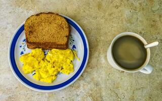 Breakfast scrambled eggs with toast slices nicely arranged on plate. photo