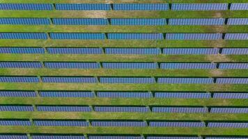 Flight over a field of solar panels in sunny summer day. Ecological innovation video