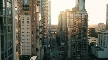 vuelo a lo largo el calle Entre rascacielos a puesta de sol. vancouver, Canadá video