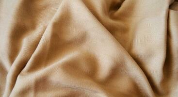 gold fabric background, silk fabric, satin textile texture, abstract background, luxury background photo