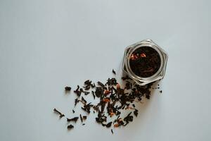 leaf tea with pieces of fruit in a jar, black tea, a jar of tea on a gray background, international tea day, banner photo