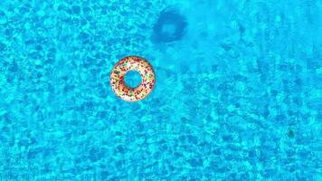 topo baixa Visão Como uma homem mergulhos para dentro a piscina e nada com inflável rosquinha video