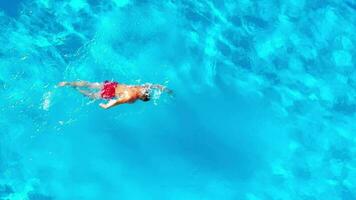 aérien vue de une homme dans rouge short nager dans le bassin video