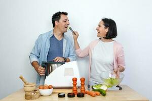 sonriente mujer da hombre ensalada con cocina tenazas foto