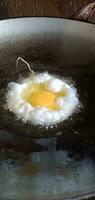 revuelto huevos siendo frito en un fritura pan foto