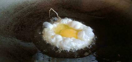 revuelto huevos siendo frito en un fritura pan foto