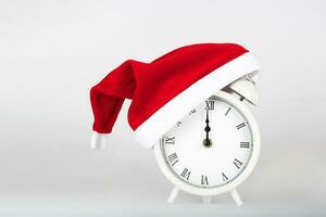 Vintage alarm clock in Santa Claus hat. photo