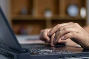 Male hands typing on laptop keyboard and surfing internet on desk, business concept and technology, internet network communication photo