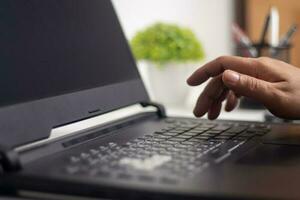 Male hands typing on laptop keyboard and surfing internet on desk, business concept and technology, internet network communication photo