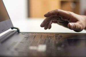 Male hands typing on laptop keyboard and surfing internet on desk, business concept and technology, internet network communication photo