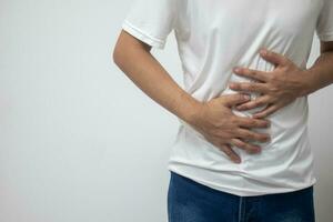 man having abdominal pain on white background photo