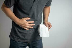 hombre con dolor de estómago participación baño papel foto