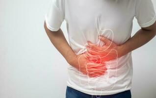 man having abdominal pain on white background photo