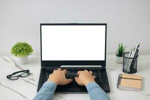 man's hands working on laptop in front of white photo