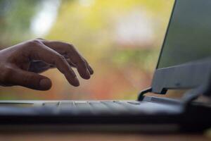 Male hands typing on laptop keyboard and surfing internet on desk, business concept and technology, internet network communication photo